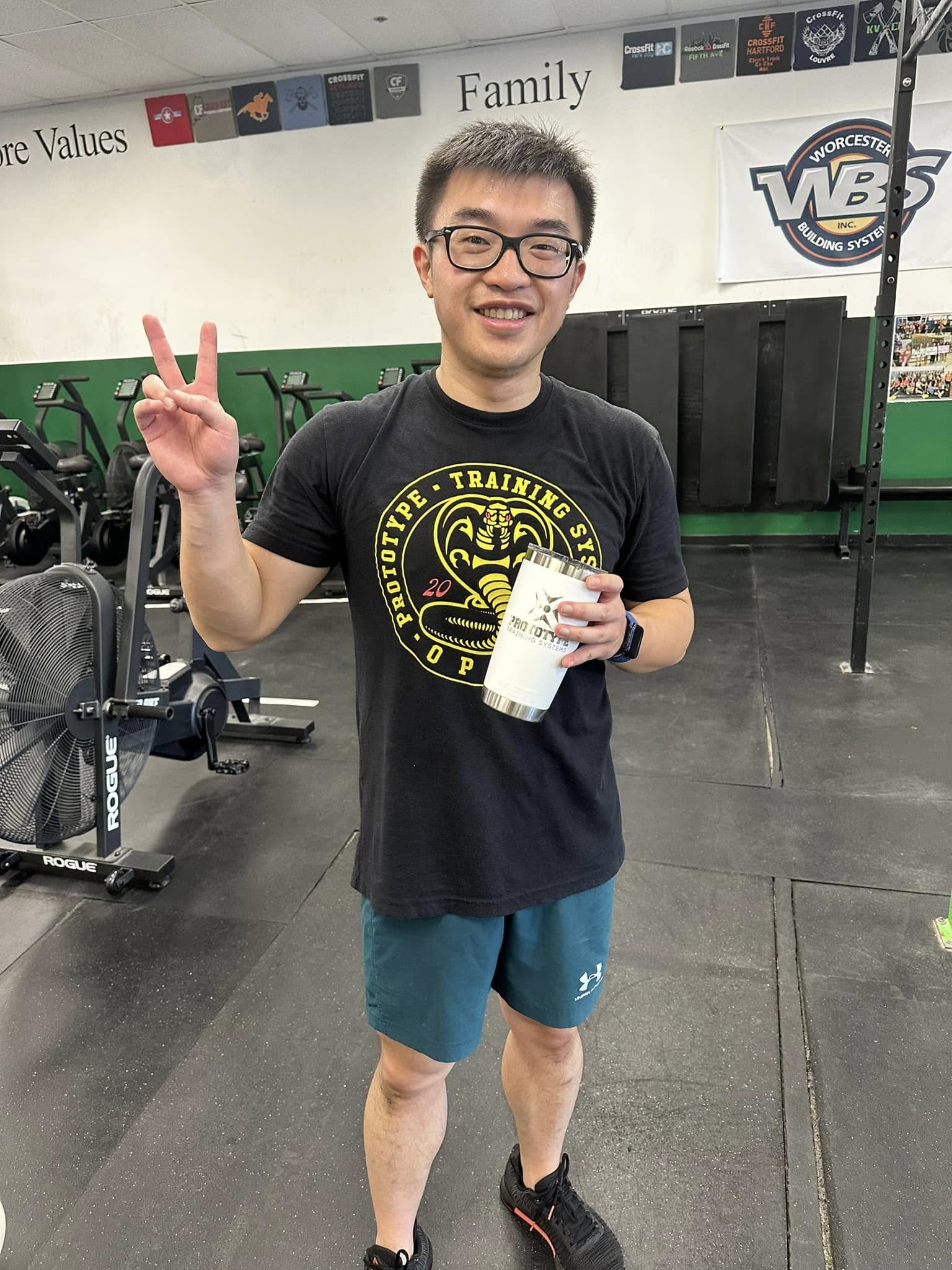 Rui Xu holding his Committed Club Yeti after his 1,000th workout at Prototype