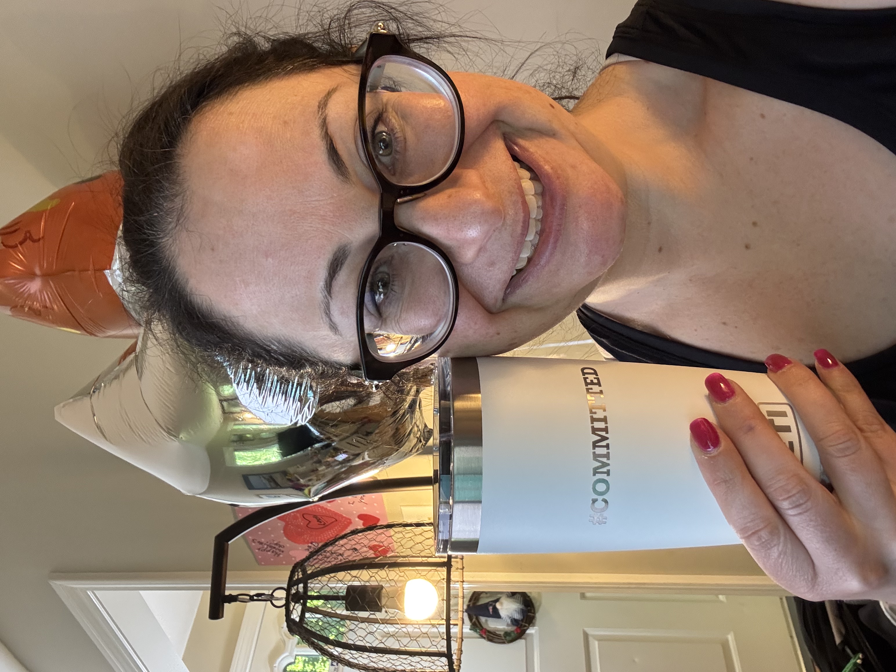 Shana Doiron holding up her 1,000th-class mug at Prototype Training Systems