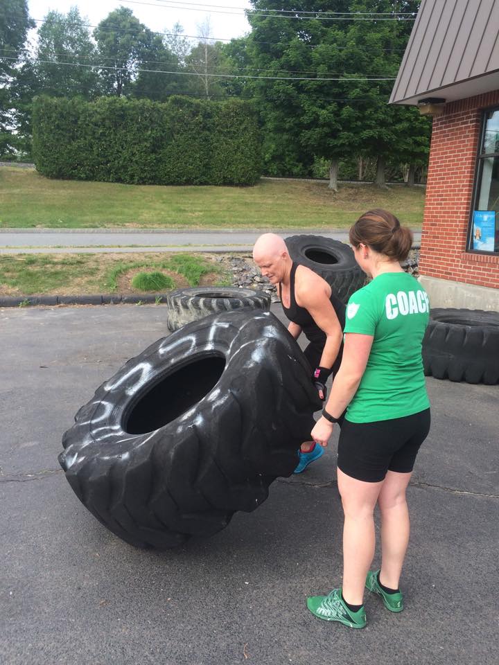 Jean Hanks flipping a tire at Prototype while going through breast cancer treatment