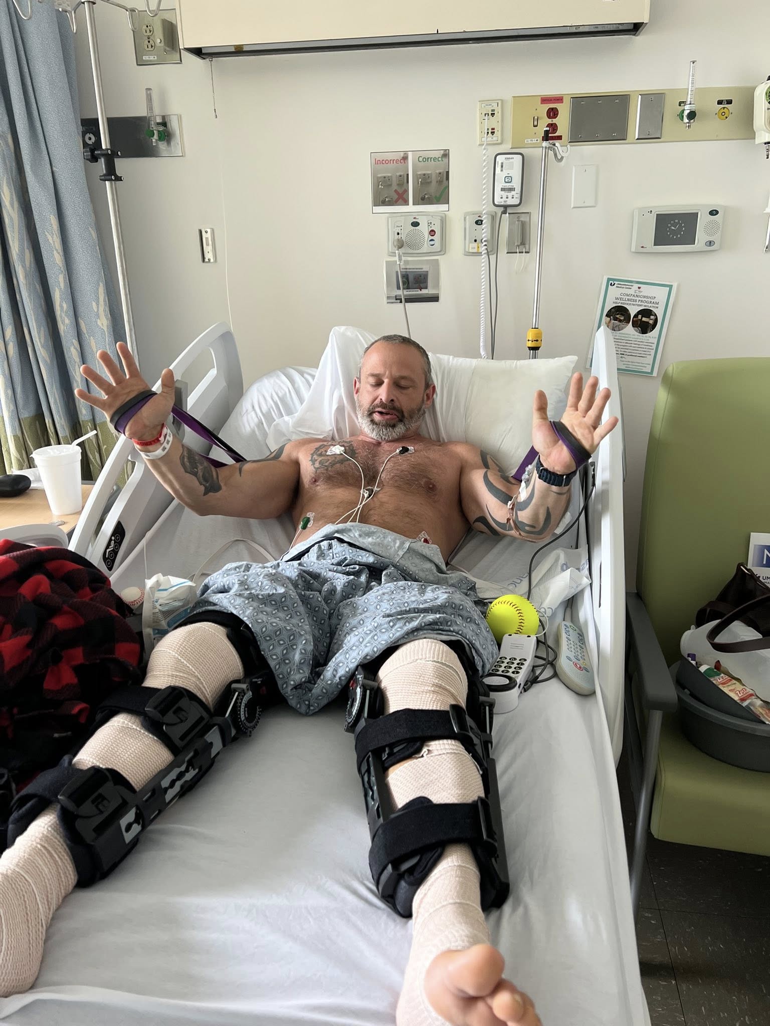 Tony Pittman working out with resistance bands from his hospital bed in the ICU, joining the 9am class virtually