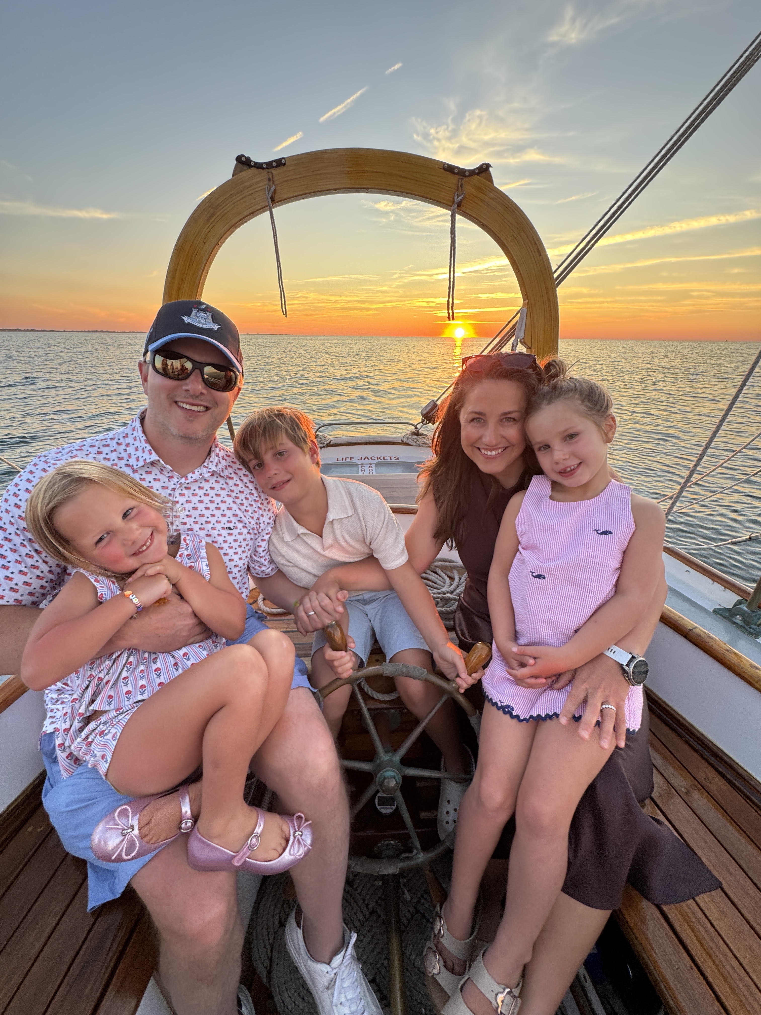 Megan Braswell with her husband and three children on a sailboat at sunset
